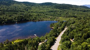Un lago rodeado de un bosque denso y una carretera.
