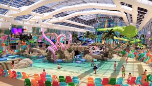 A large indoor water park with slides, a pool, and colorful chairs. - Delightful 3BR Condo Near Gulf Shores With Pool & Hot Tub (Gulf Shores)