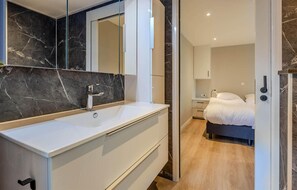 A modern bathroom with a white vanity, a large mirror, and a marble backsplash. - Awesome home in Voorthuizen (Voorthuizen)