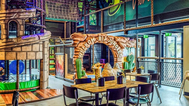 A restaurant with a rustic archway, a camel statue, and a view of the city through large windows. - Awesome home in Voorthuizen (Voorthuizen)