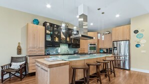 Una cocina moderna con una isla central, electrodomésticos de acero inoxidable y armarios de madera.