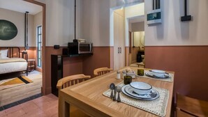 A hotel room with a bed, a dining area with a table set for two, a microwave, and a television. - Oliva I Modern 2 Bed Apart in Mexico City (Mexico City)