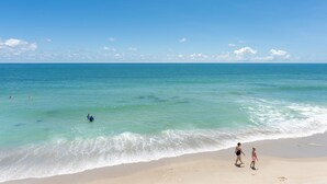 Una playa con aguas azules cristalinas y una orilla arenosa.