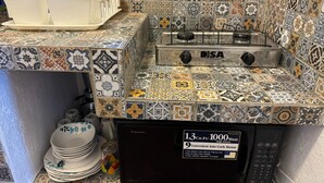 A kitchen with a patterned backsplash, a stove, and a microwave. - Casa Icaco  (Puerto Escondido)