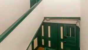 A narrow stairway with green railings and a door at the bottom. - Room-charming Lisboa Room to Rent With S (Lisbon)