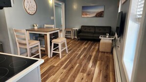 A compact living space with a dining area, a sofa, and a TV.