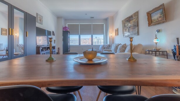 A dining area with a wooden table, black chairs, and a decorative bowl centerpiece.