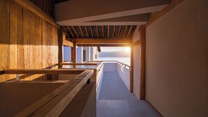 A corridor with wooden benches and a view of the sea.