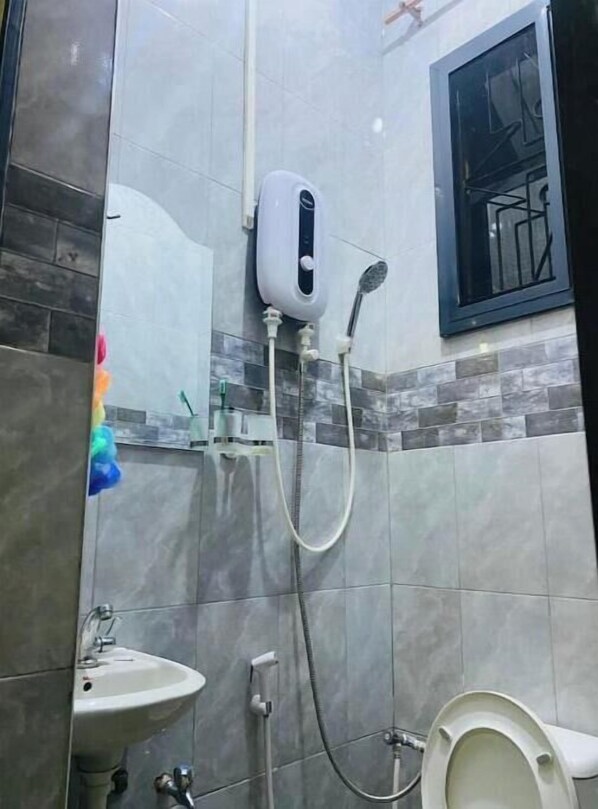 Un bagno con doccia, lavandino e WC.