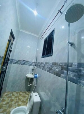 Un bagno compatto con servizi igienici, bidet e doccia.