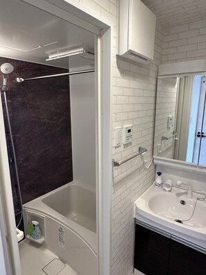 A modern bathroom with a bathtub, a shower, a sink, and a mirror. - CRYSTAL&RESORT EXCLUSIVE (Fukuoka)
