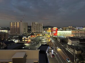 A cityscape at night with illuminated billboards, a McDonald's, and a parking lot. - CRYSTAL&RESORT EXCLUSIVE (Fukuoka)