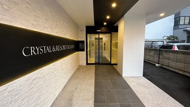 A modern building entrance with a sign reading "CRYSTAL & RESORT EXCLUSIVE". - CRYSTAL&RESORT EXCLUSIVE (Fukuoka)