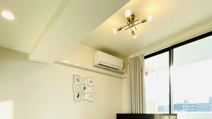 A modern living room with a sofa, a TV, and a small table with a remote control. - CRYSTAL&RESORT EXCLUSIVE (Fukuoka)