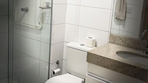 Un baño con inodoro, lavabo y ducha.
