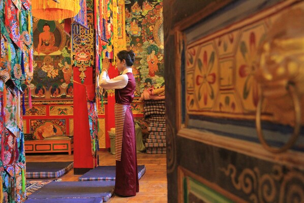 A traditional room with intricate wall decorations, a bed, and a wooden cabinet. - FEIFAN Historic Tibetan Hotel (Garze)
