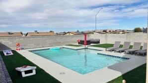 A swimming pool with a red umbrella, lounge chairs, and a small kiddie pool. - Perfect for Families & Groups in Fortuna Foothills (Yuma)