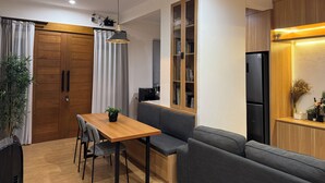 Une cuisine moderne avec des meubles en bois, une bibliothèque intégrée et un réfrigérateur noir.