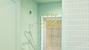 A room with a light green wall, a white door, and a window with blinds.