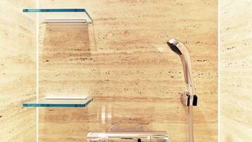 A bathroom with a wooden wall, a shower with a handheld showerhead, and two clear glass shelves.