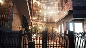 A multi-level building with balconies, a brick facade, and a gated entrance. - Q-ROOMS.HARAJUKU (Tokyo)