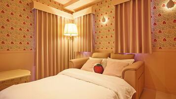 A hotel room with a bed, curtains, a lamp, and a wall with a pattern.