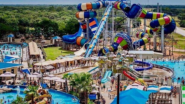 A water park with multiple water slides, pools, and a large central water feature.