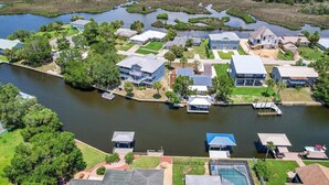 An aerial view of a residential area with houses, a river, and docks. - Large Game Room • Kayaks • No Steps • Waterfront (Crystal River)