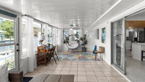 A spacious living area with a dining table, a round chair, and a colorful rug. - Large Game Room • Kayaks • No Steps • Waterfront (Crystal River)