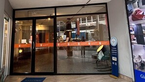 A hotel entrance with a reception desk, a 'Cashless payments preferred' sign, and a 'Welcome' mat. - Glur Hostel Pattaya Walking Street (Pattaya)