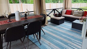 An outdoor patio with a table, chairs, and a sofa. - Trackside Guesthouse w/ Pool (Clifton Park)