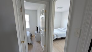 Ein Flur mit weißen Wänden und Türen zu einem Schlafzimmer und einem Badezimmer.