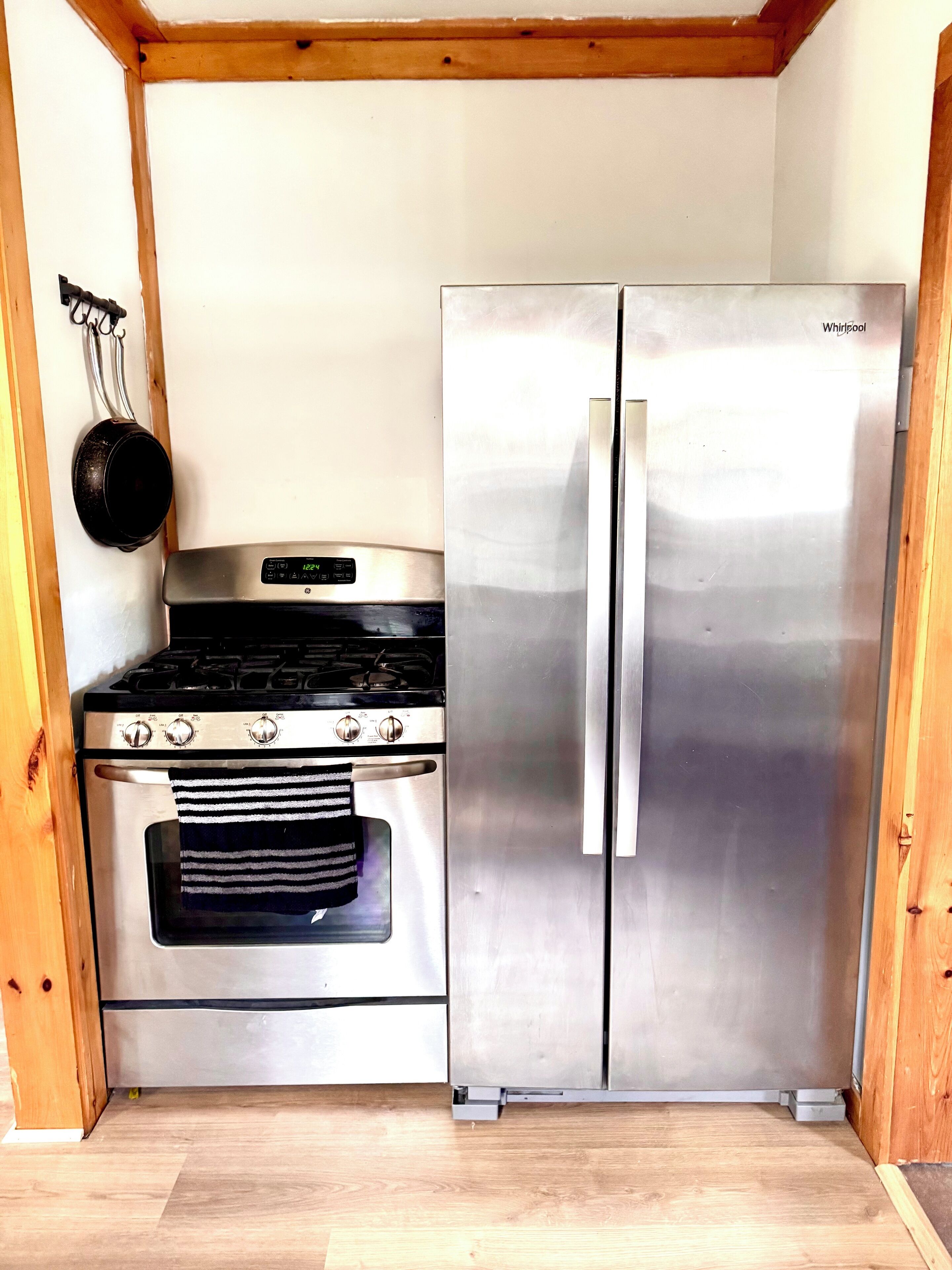 Cocina compacta con estufa, horno y refrigerador de acero inoxidable.