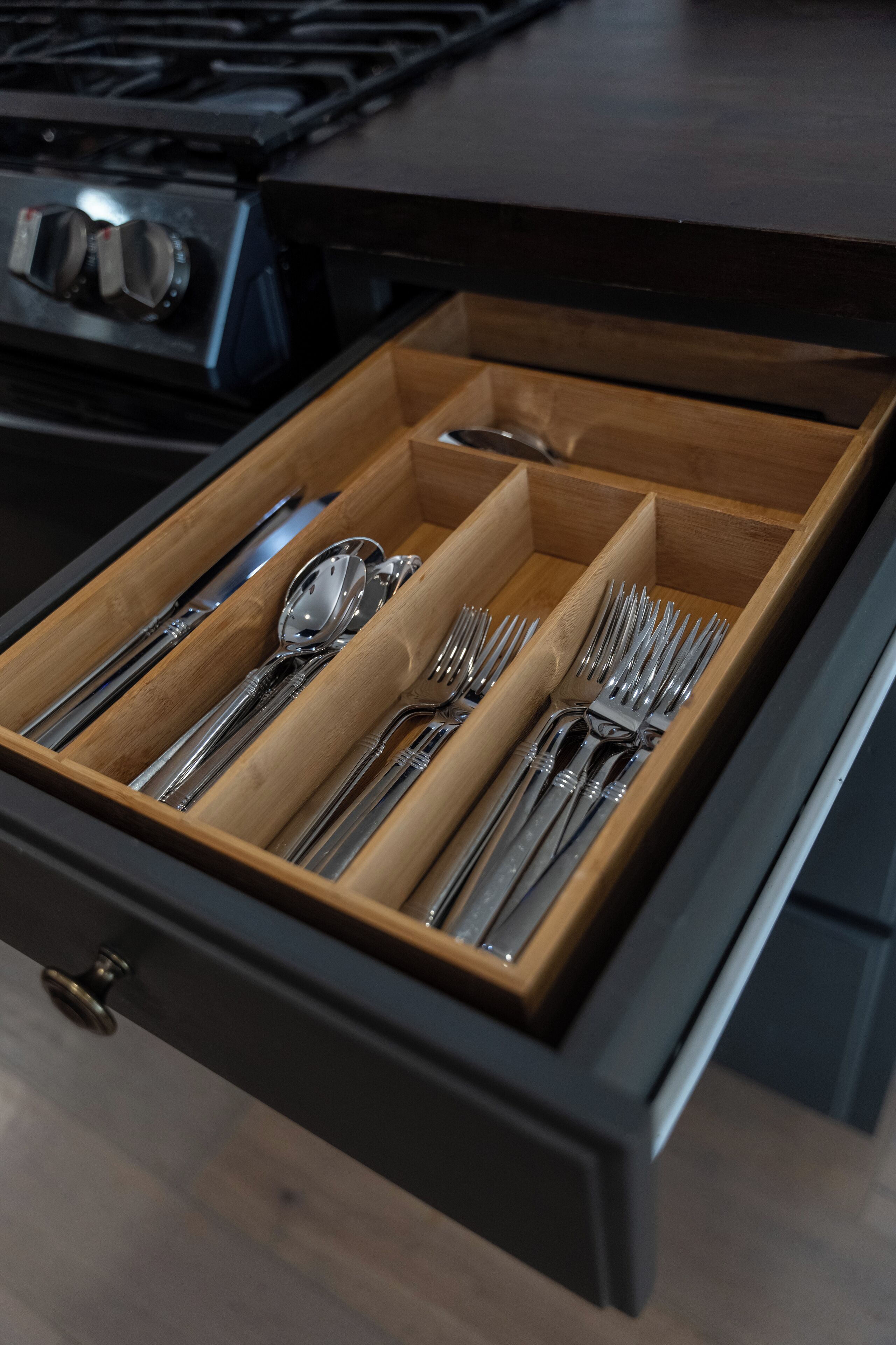A drawer with neatly organized silverware including forks, knives, and spoons.