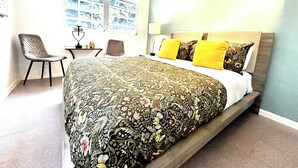 Un dormitorio con una cama grande, un escritorio y una silla.