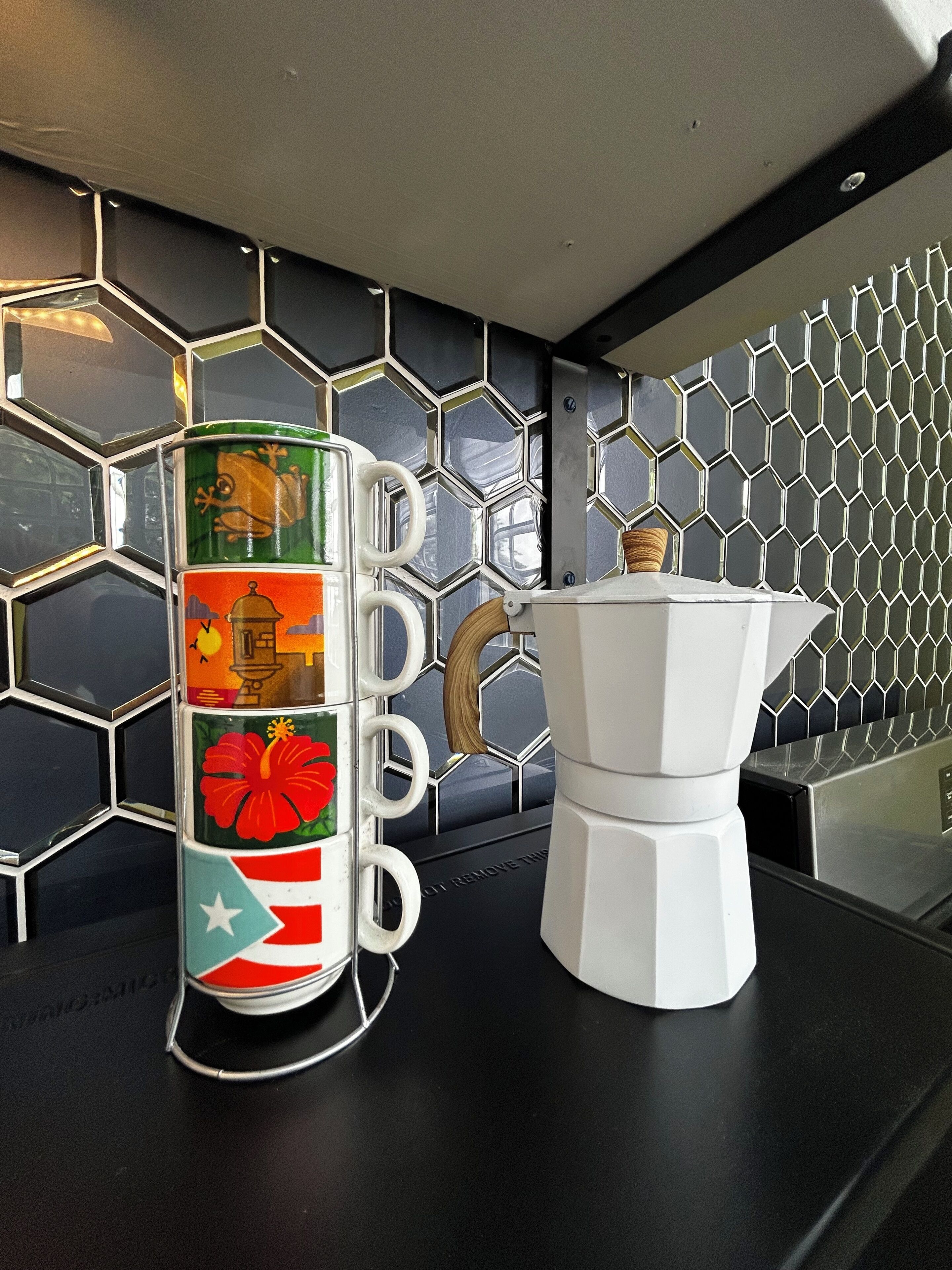A kitchen counter with a coffee maker and a decorative container with holiday-themed designs.