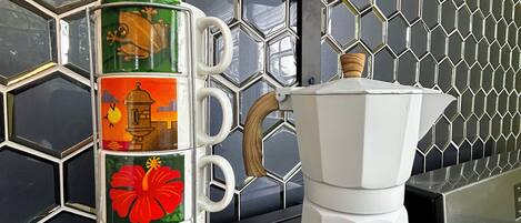 A kitchen counter with a coffee maker and a decorative container with holiday-themed designs.