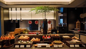 A buffet with various food items and a central decorative plant. - JOYA Hotel Chengdu Taikoo Li IFS (Chengdu)
