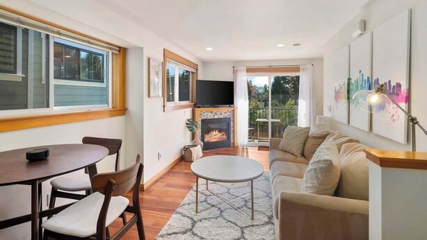 A living room with a fireplace, a sofa, a coffee table, and a TV. - Peaceful City Retreat • Family & Pet Friendly (Seattle)