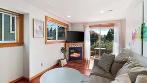 A living room with a fireplace, a television, and a sofa. - Peaceful City Retreat • Family & Pet Friendly (Seattle)