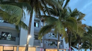 A modern hotel with multiple floors, outdoor seating, and a pool area. - Fanaseti (Conakry)