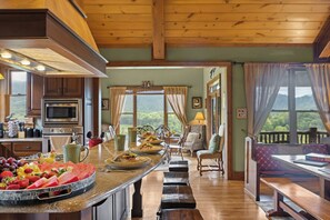 Una cocina con barra americana, comedor con vistas y un rincón de descanso acogedor.