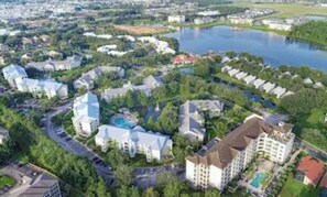 Vue aérienne d’un quartier résidentiel avec des maisons, une piscine et un lac.