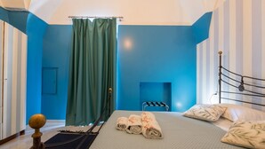 A hotel room with a bed, a window with curtains, and a metal bed frame.