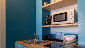 A compact kitchen with a sink, a microwave, and a stove.