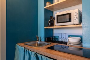A compact kitchen with a sink, a microwave, and a stove.
