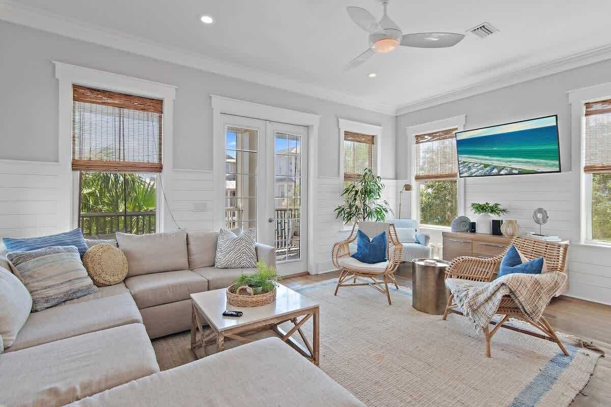 A spacious living room with a sofa, chairs, a coffee table, and a television.