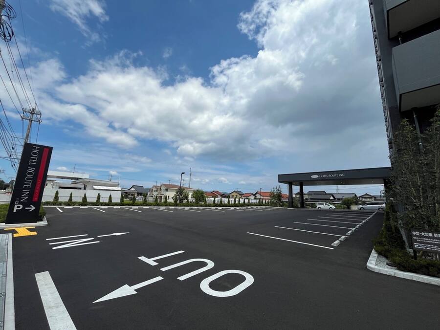 Un estacionamiento de hotel con flechas direccionales y un cartel del Hotel Route Inn.