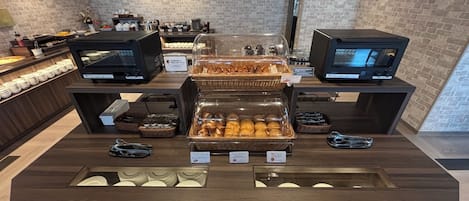 A buffet setup with various food items and a self-service station.
