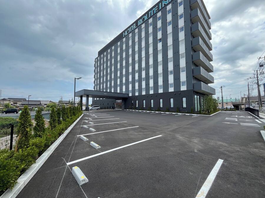 A modern hotel with a large parking lot and a covered entrance.